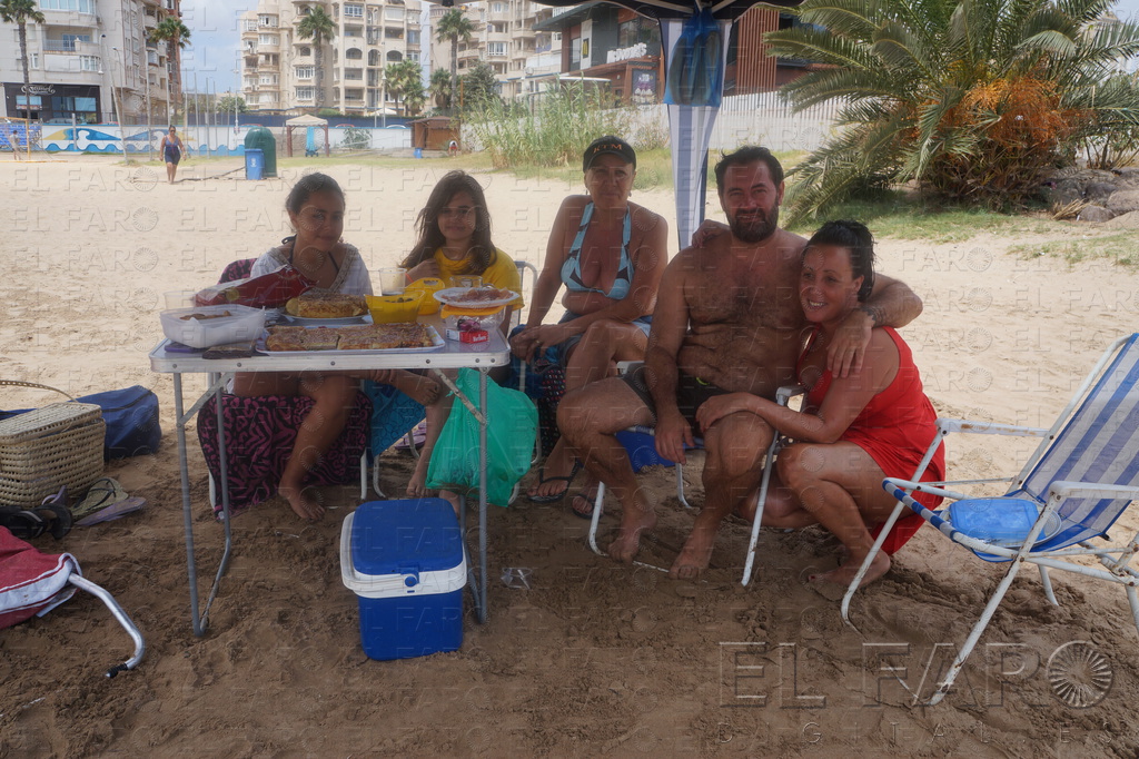 Una familia bajo una pérgola en la playa de San Lorenzo.