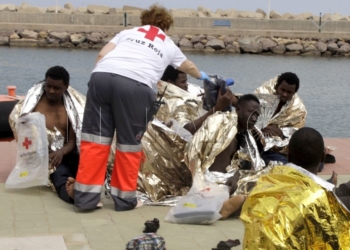 GRA332. MELILLA, 19/05/2017.- Un efectivo de la Cruz Roja atiende esta tarde a varios de los 24 inmigrantes de origen subsahariano después de que la patera con la que intentaban llegar a Melilla haya naufragado. El rescate se ha producido en las inmediaciones de Aguadú (al norte de Melilla), y los inmigrantes han sido trasladados al puerto deportivo en la embarcación del GEAS de la Guardia Civil. EFE/F.G.GUERRERO