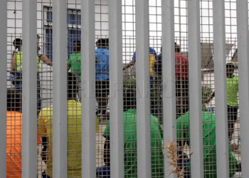 GRAF6397. MELILLA, 19/07/2019.- Un grupo de inmigrantes subsaharianos tras el muro del Centro de Estancia Temporal de Inmigrantes (CETI), este viernes en Melilla, donde en un salto masivo a la valla que hace frontera con Marruecos, alrededor de 50 personas han conseguido acceder a la ciudad autónoma española. EFE/ Francisco García Guerrero