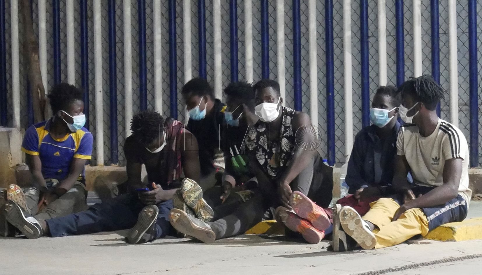 MELILLA, 13/10/2021.- Varios migrantes de origen subsahariano permanecen bajo vigilancia policial tras acceder a Melilla saltando el perímetro fronterizo entre España y Marruecos, en la madrugada de este miércoles. EFE/Paqui Sánchez