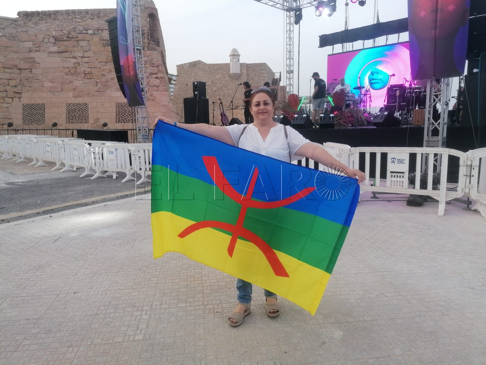 En la imagen una melillense que asiste al Iwa Fest porta la bandera amazigh