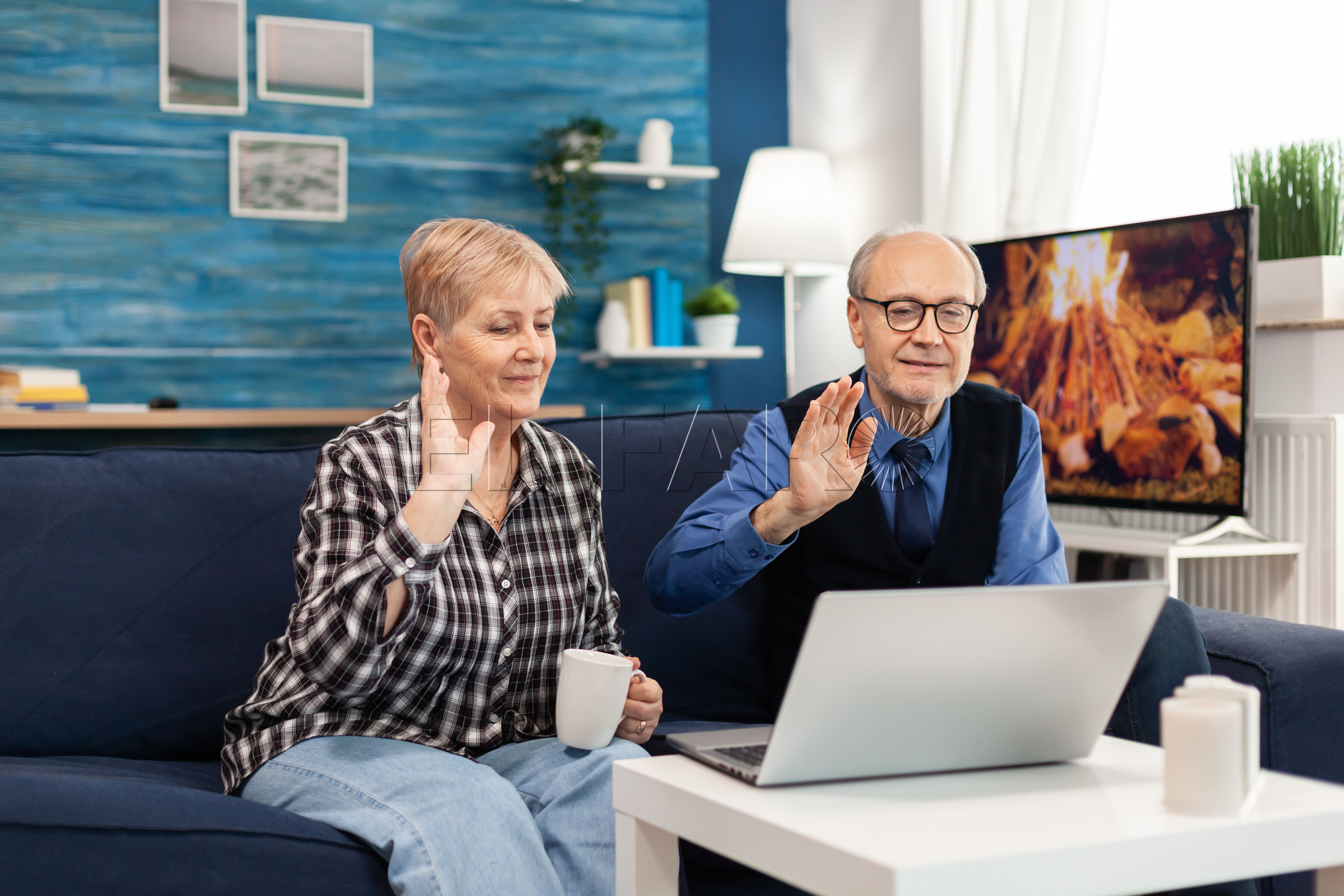cheerful senior couple living room waving webcam during online call La mayor subida de las pensiones de la historia