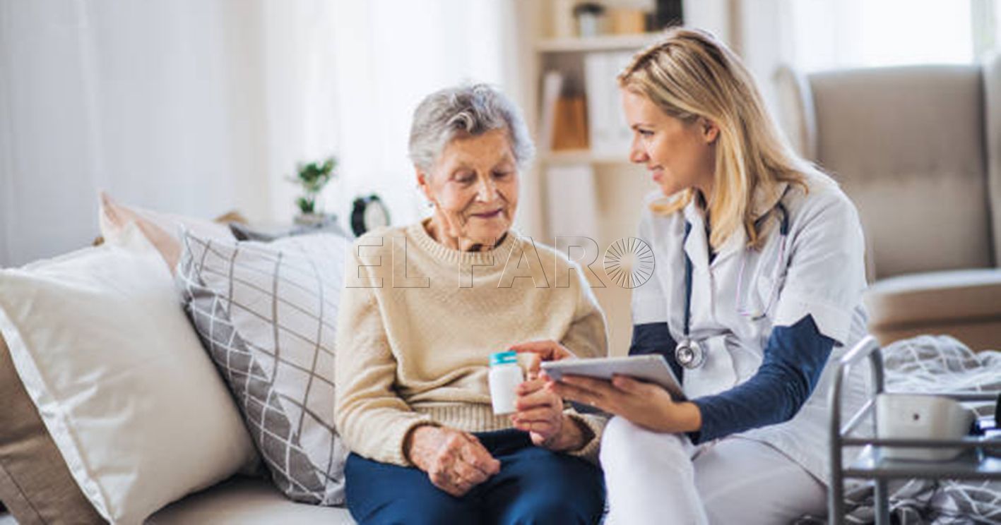 A young health visitor with tablet explaining a senior woman how to take medicine and pills.