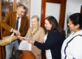 2. El delegado de Atende hace entrega de un ejemplar a Isabel Gómez una de las usuarias colaboradoras en compañía de sus auxiliares Atende presenta el libro de recetas "Dulces recuerdos del sur", un homenaje a la sabiduría de nuestros mayores
