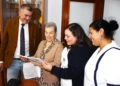 4. El delegado de Atende hace entrega de un ejemplar a Isabel Gómez una de las usuarias colaboradoras en compañía de sus auxiliares Atende presenta el libro de recetas "Dulces recuerdos del sur", un homenaje a la sabiduría de nuestros mayores
