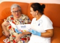 7. La usuaria colaboradora Carmen Algarra ojeando el libro de Dulces Recuerdos del Sur en compañía de su auxiliar Saloua Atende presenta el libro de recetas "Dulces recuerdos del sur", un homenaje a la sabiduría de nuestros mayores
