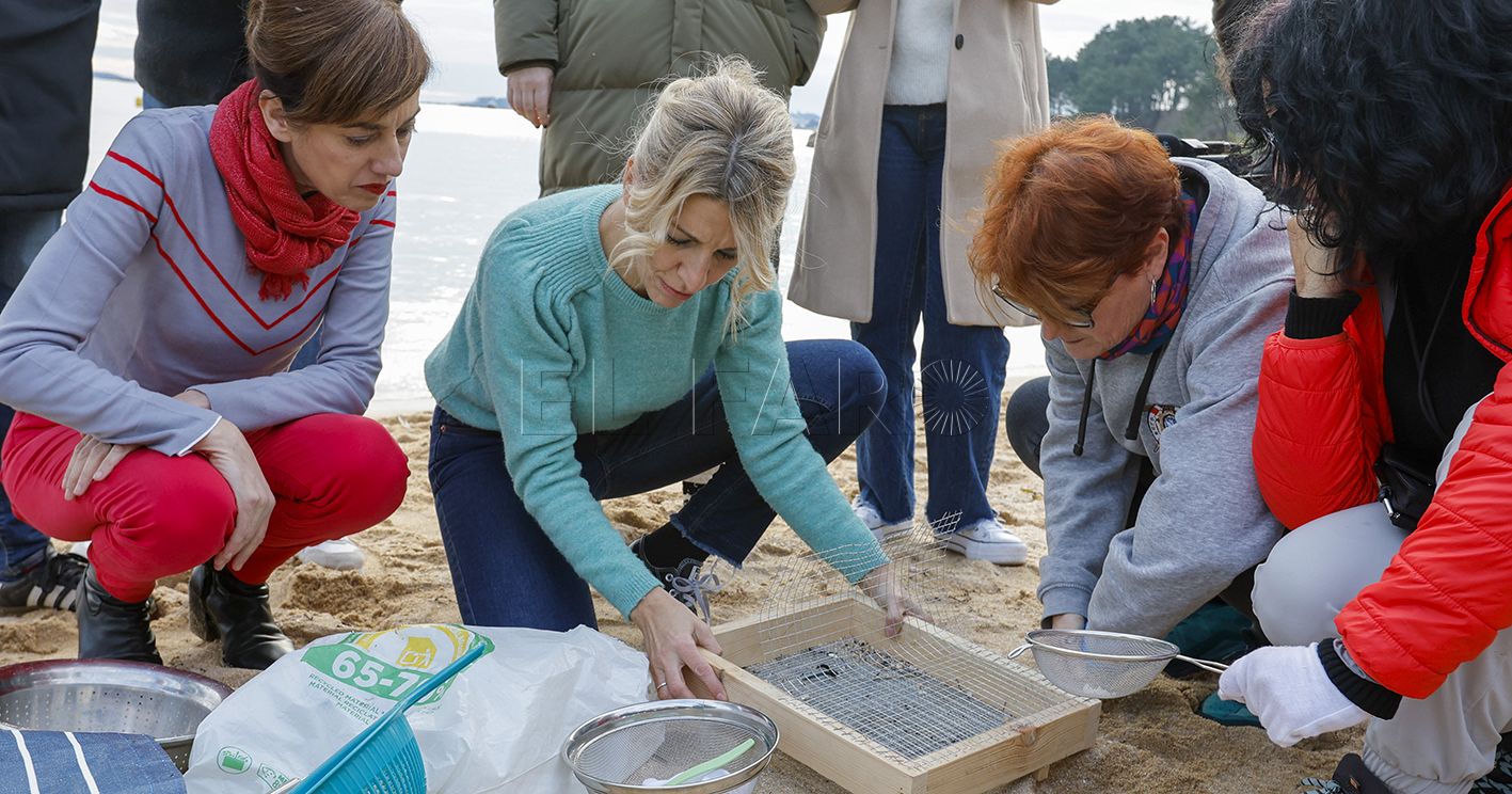 POBRA DO CARAMIÑAL, A CORUÑA 12/01/2024.- La vicepresidenta segunda del Gobierno y líder de Sumar, Yolanda Díaz, y la candidata de Sumar Galicia a la Xunta, Marta Lois, (izq) comprueba el funcionamiento de las labores de limpieza de granza o pellets, esta tarde en la Playa de la Corna, en Pobra do Caramiñal. EFE/Lavandeira jr