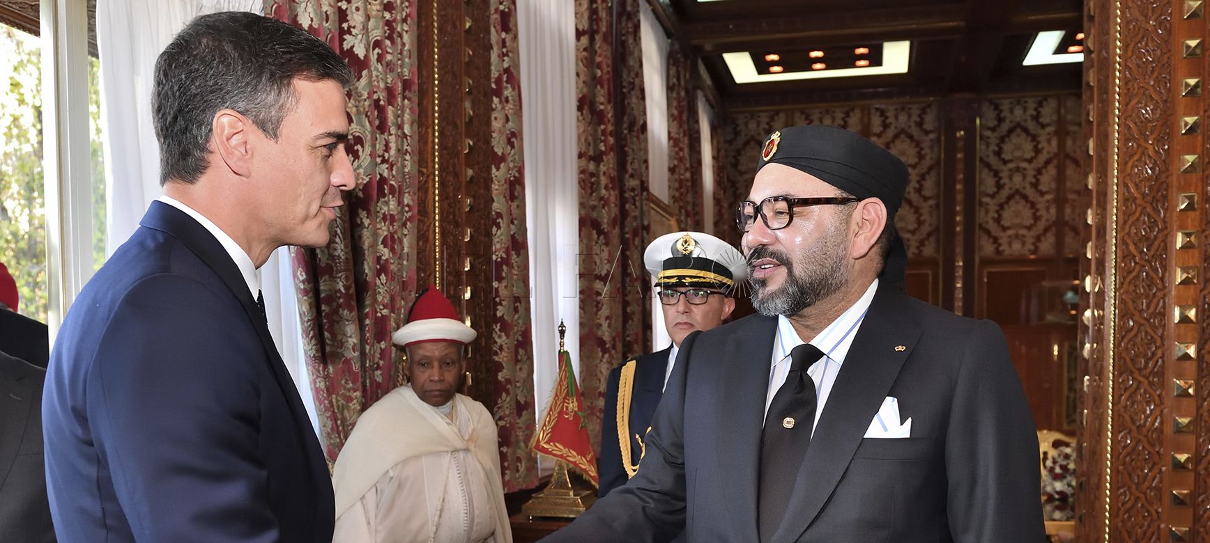 This photo provided by the Moroccan Royal Palace shows Spanish Prime Minister Pedro Sanchez, left, greeted by Moroccan King Mohammed VI prior to their lunch at the Royal Palace in Rabat, Morocco, Monday, Nov. 19, 2018. Sanchez urged greater cooperation on migration while making his first visit Monday to Morocco, a jumping-off point for a growing number of migrants trying to reach Spain and get a foothold in Europe. (Moroccan Royal Palace via AP)