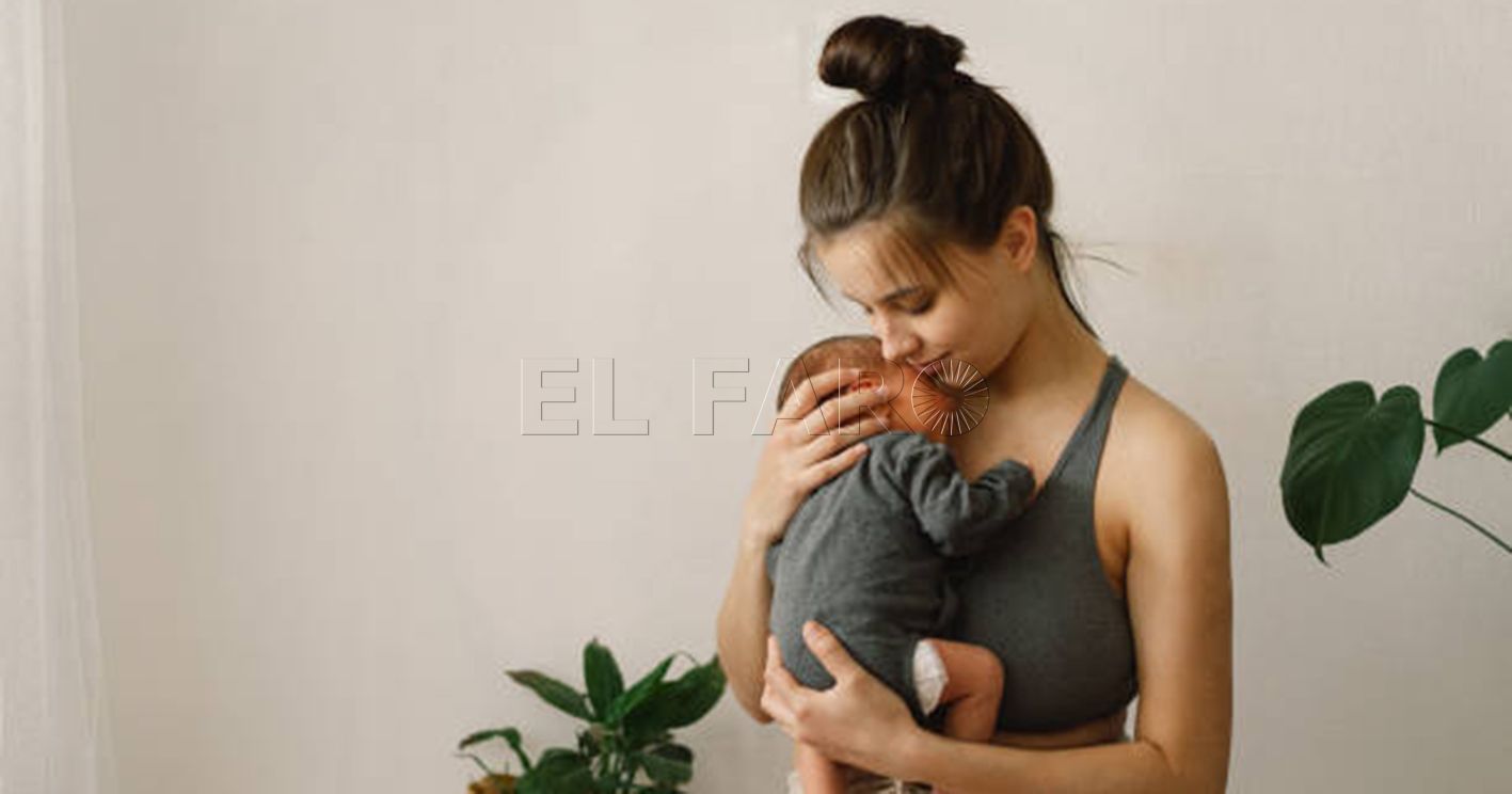 Mother holds and hugs her newborn baby son at home. Happy infant and mom. Mother's day concept