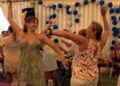 mujeres bailando El Club Scorpio de Aventuras inaugura su caseta de la Feria anunciando la dimisión de su presidente