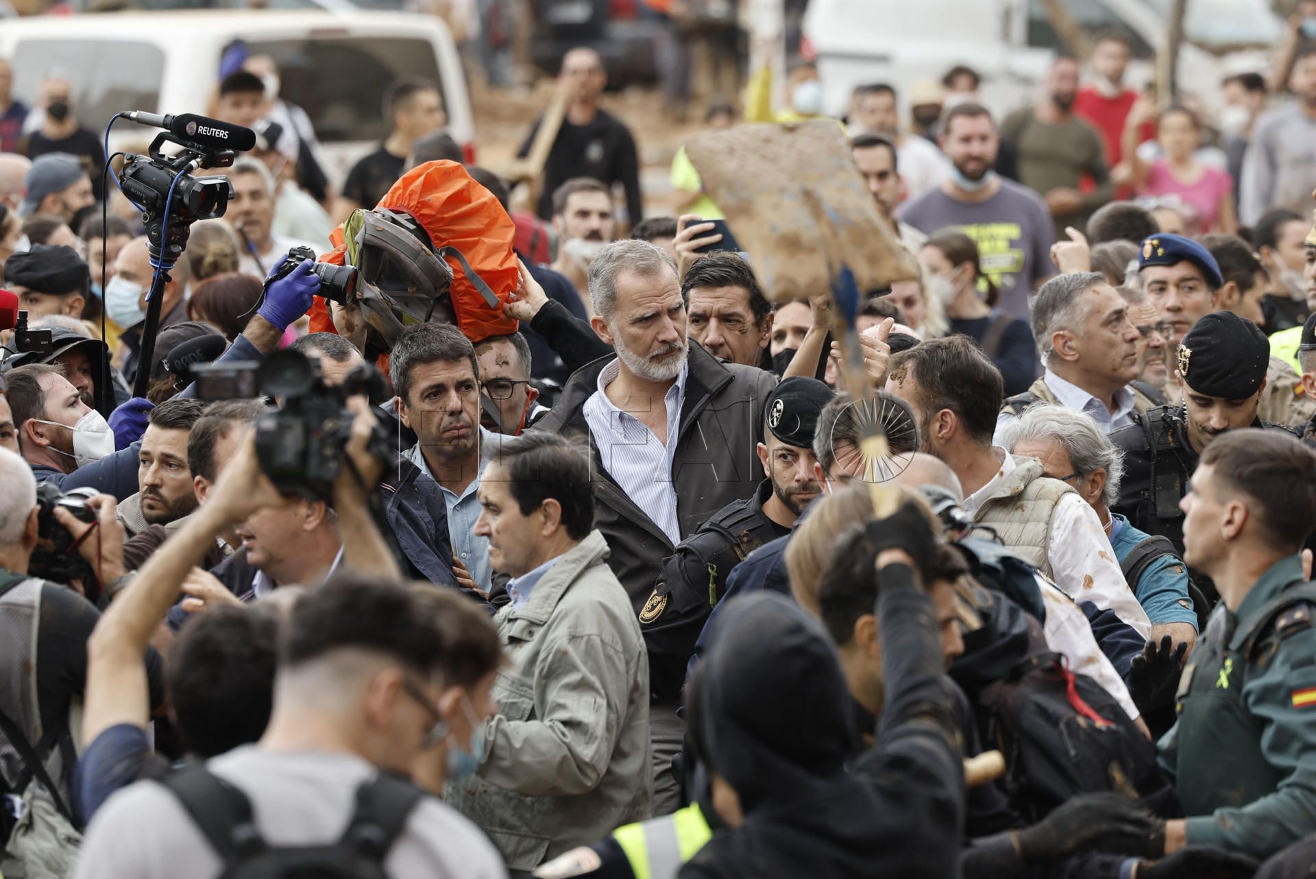 El rey Felipe (c), junto al presidente de la Generalitat de Valencia, Carlos Mazón (c-i), durante su visita a Paiporta este domingo. Gritos de 'fuera', así como lanzamiento de barro, están recibiendo a la comitiva de los reyes de España, el presidente del Gobierno, Pedro Sánchez, y el president de la Generalitat, Carlos Mazón, a su llegada al centro de Paiporta.EFE/ Biel Aliño