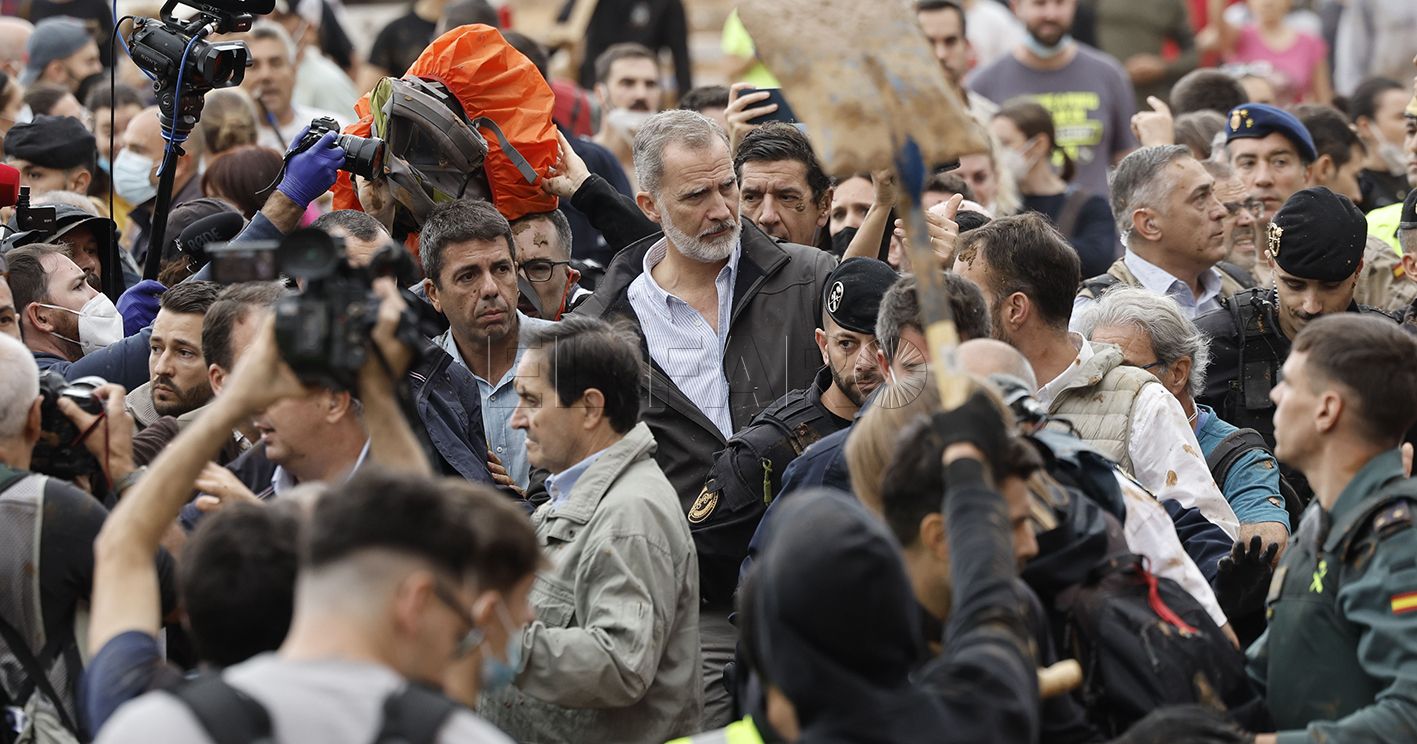 El rey Felipe (c), junto al presidente de la Generalitat de Valencia, Carlos Mazón (c-i), durante su visita a Paiporta este domingo. Gritos de 'fuera', así como lanzamiento de barro, están recibiendo a la comitiva de los reyes de España, el presidente del Gobierno, Pedro Sánchez, y el president de la Generalitat, Carlos Mazón, a su llegada al centro de Paiporta.EFE/ Biel Aliño